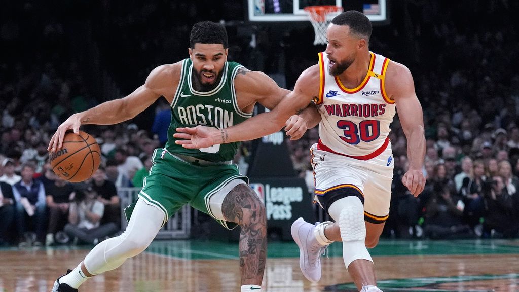 Boston Celtics forward Jayson Tatum, left, drives to the basket against Golden State Warriors guard Stephen Curry during the second half of an NBA basketball game, Wednesday, Nov. 6, 2024, in Boston. (AP Photo/Charles Krupa)