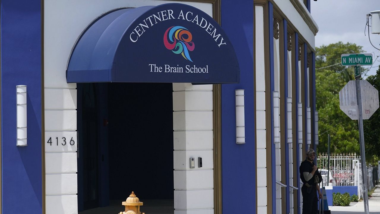 A security guard walks the perimeter of Centner Academy on Tuesday in Miami. (AP Photo/Marta Lavandier)