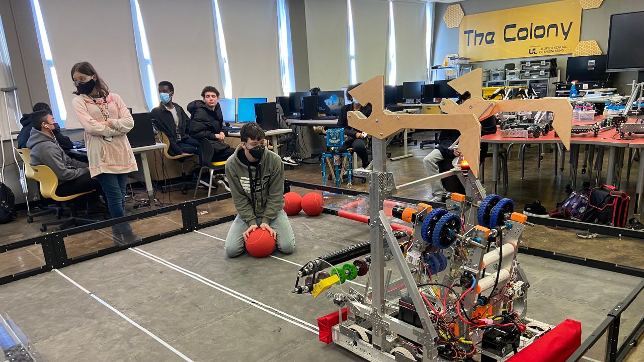 Aiden Roe demonstrates the robot he and classmates are taking to a competition in Tennessee. (Spectrum News 1/Adam K. Raymond)