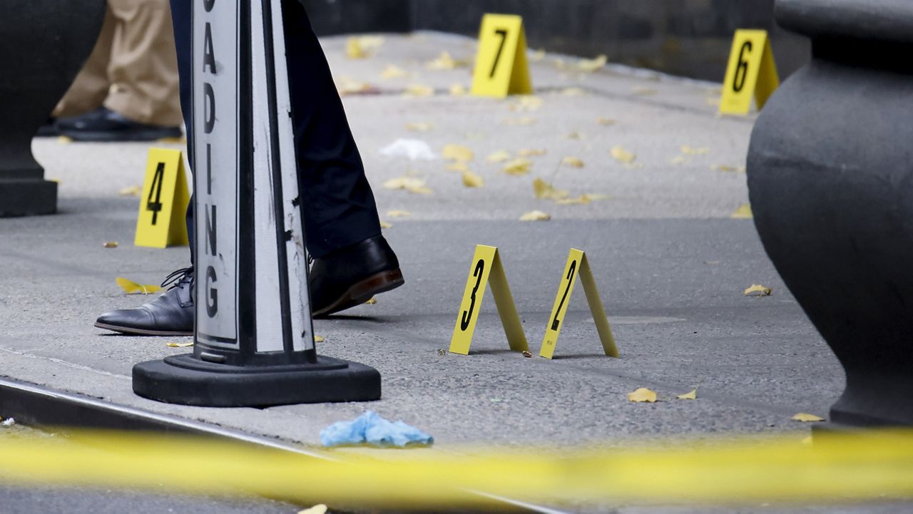 Members of the New York police crime scene unit investigate bullets lying on the sidewalk at the scene outside the Hilton Hotel in midtown Manhattan where Brian Thompson, the CEO of UnitedHealthcare, was fatally shot, Wednesday, Dec. 4, 2024, in New York.