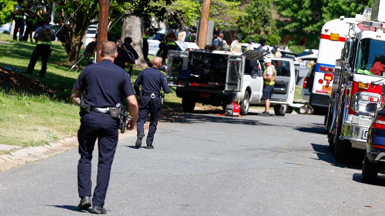 Charlotte-Mecklenburg Police Department officers walk in the neighborhood where a shooting took place in Charlotte, N.C., Monday, April 29, 2024. The Charlotte-Mecklenburg Police Department says officers from the U.S. Marshals Task Force were carrying out an investigation Monday afternoon in a suburban neighborhood when they came under gunfire. (AP Photo/Nell Redmond)