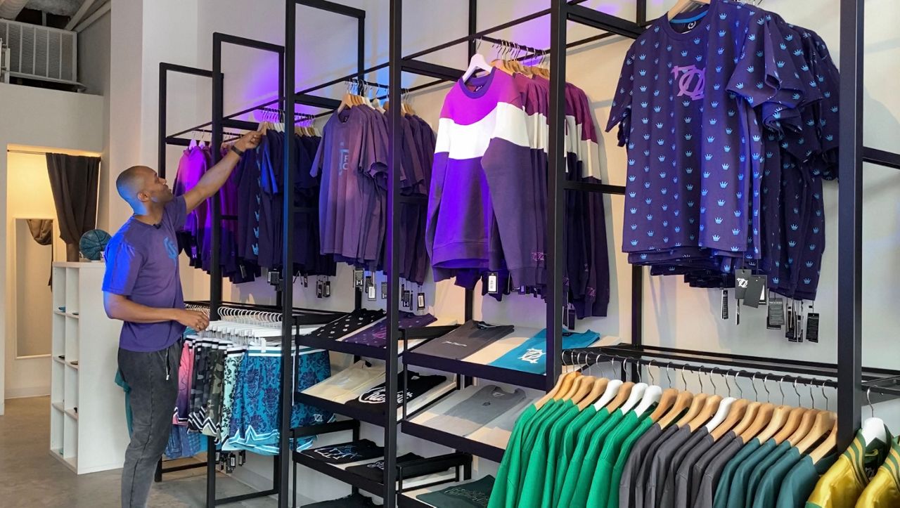Chris Moxley tidies up the display of new Charlotte FC merch at his South End store