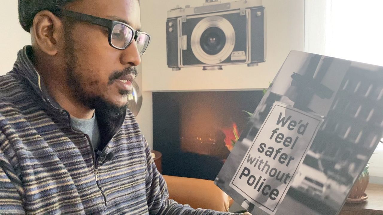 Alvin Jacobs looks a photographs in his home.