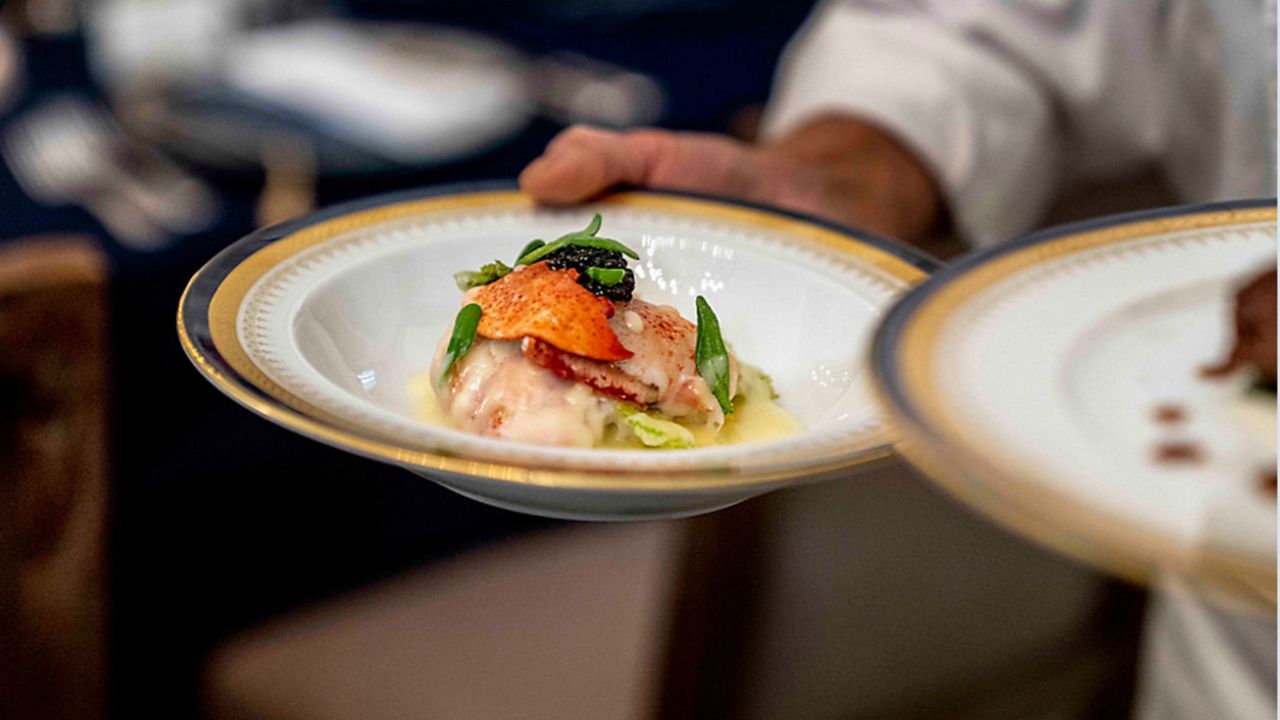 A chef carries plated food. (AP)