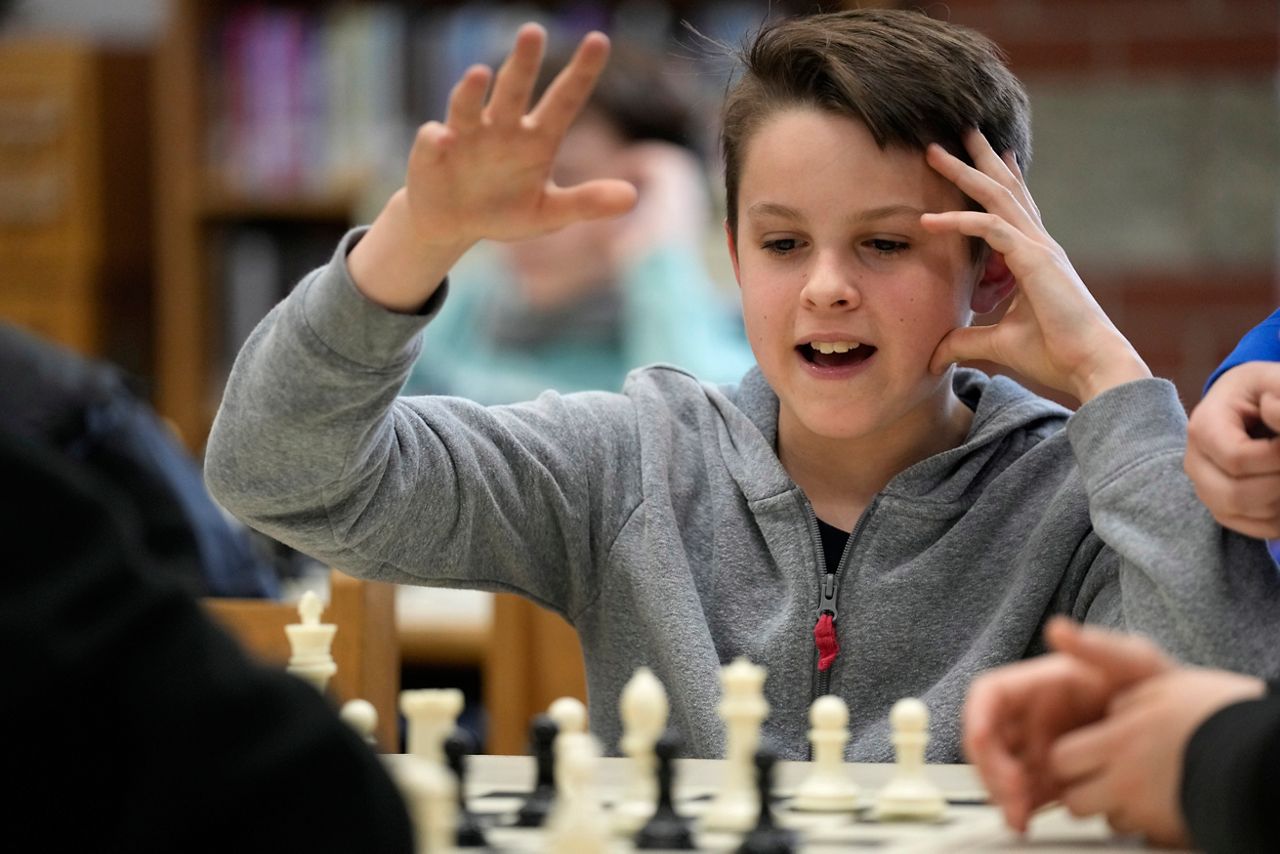 Eli Marquis, a Reeds brook Middle school student, reacts during an after-school chess team match, Tuesday, April 25, in Hampden. Part-time chess coach and full-time custodian David Bishop led his elementary and middle school teams to state championship titles this year. (AP Photo/Robert F. Bukaty)