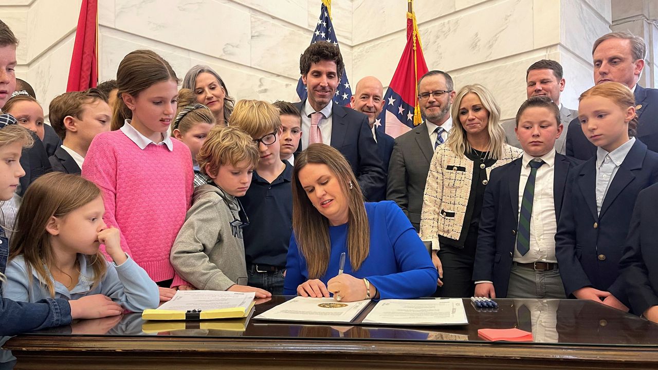 Gov. Sarah Huckabee Sanders signs bill into law surrounded by children