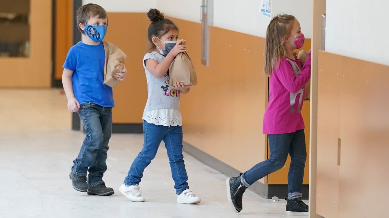 Children walking into class wearing masks. (Associated Press)