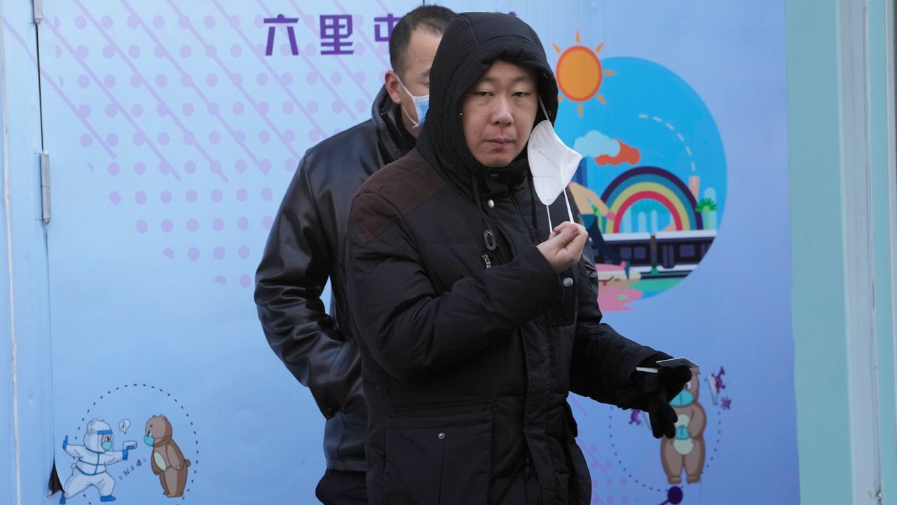 A resident pulls away a mask during COVID test in Beijing on Wednesday. (AP Photo/Ng Han Guan)