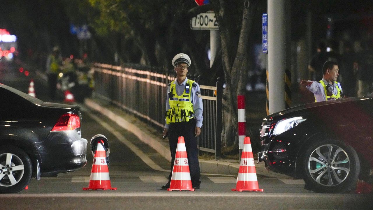 A security person stands guard near a sports center where a man rammed a car into people exercising in Zhuhai, China Monday, Nov. 11, 2024. (Kyodo News via AP)