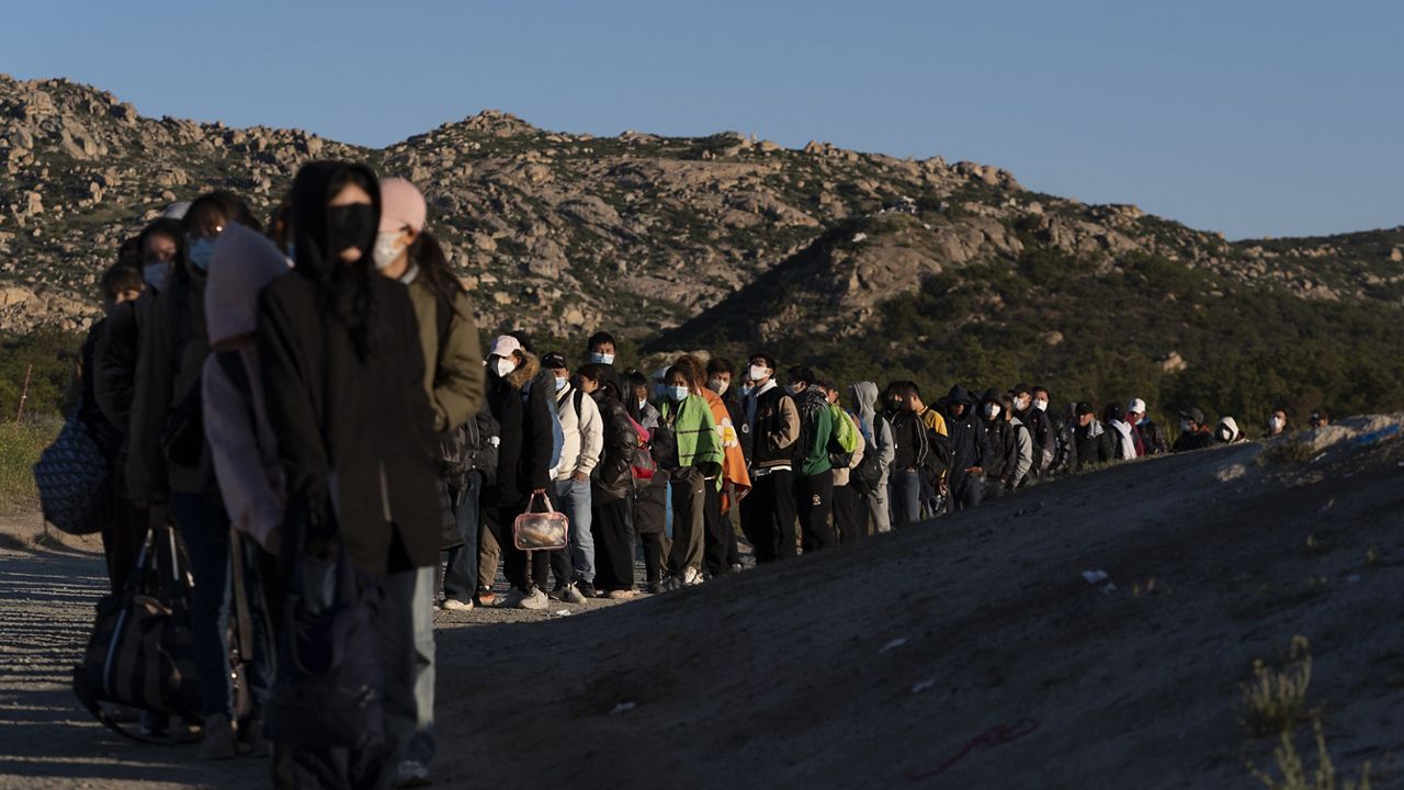 Chinese migrants wait to be processed after crossing the border with Mexico Wednesday, May 8, 2024, near Jacumba Hot Springs, Calif. (AP Photo/Ryan Sun)