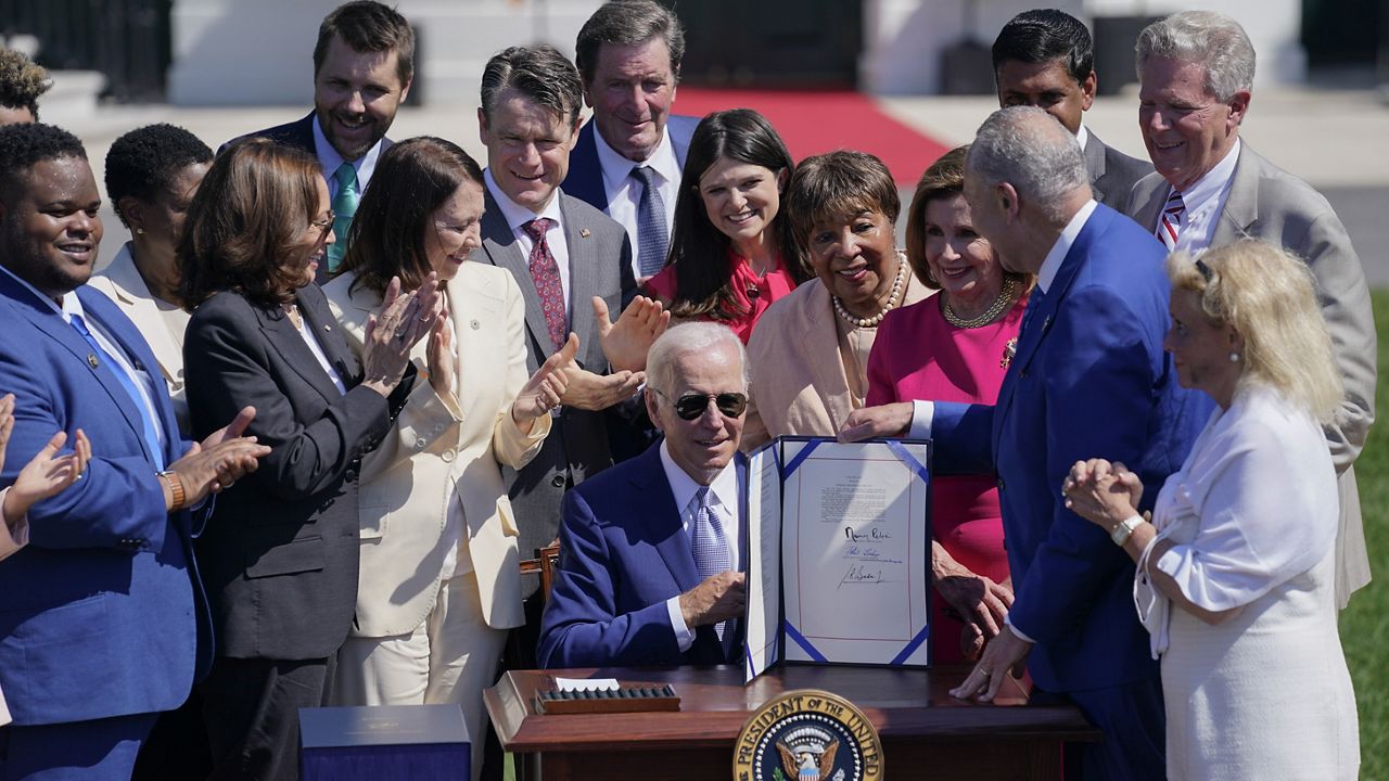 President Joe Biden holds the CHIPS and Science Act of 2022 after signing it during a ceremony on the South Lawn of the White House, Tuesday, Aug. 9, 2022, in Washington. (AP Photo/Evan Vucci, File)