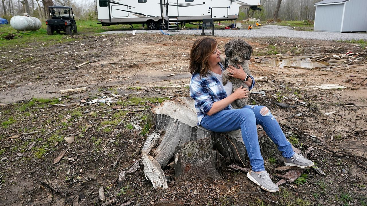 Tornado survivor Chris Bullock holds her dog, Dewey, April 21, 2022. (AP Photo/Mark Humphrey)
