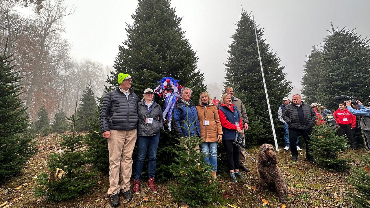 Members of the Cartner family pose with the Christmas tree chosen to adorn the White House. (Spectrum News 1/Rose Eiklor)