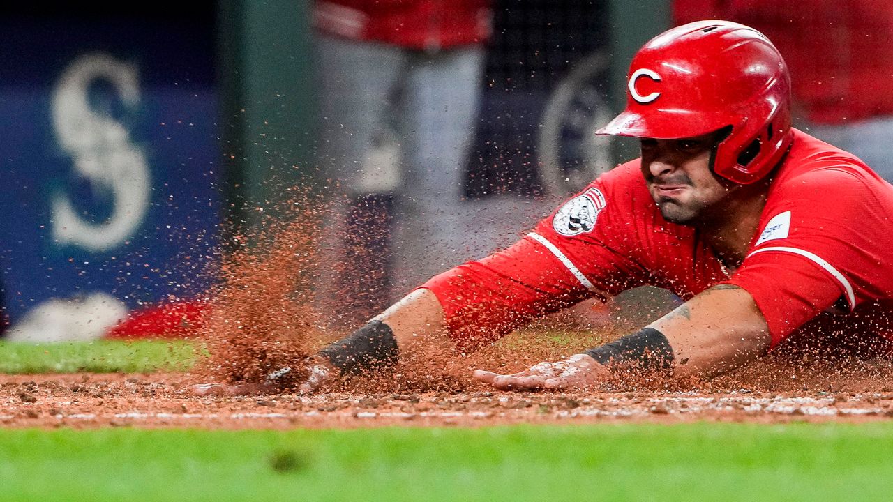 Cincinnati Reds' Christian Encarnacion-Strand slides home to score against the Seattle Mariners on a double by Jake Fraley during the fourth inning of a baseball game Monday, April 15, 2024, in Seattle. (AP Photo/Lindsey Wasson)