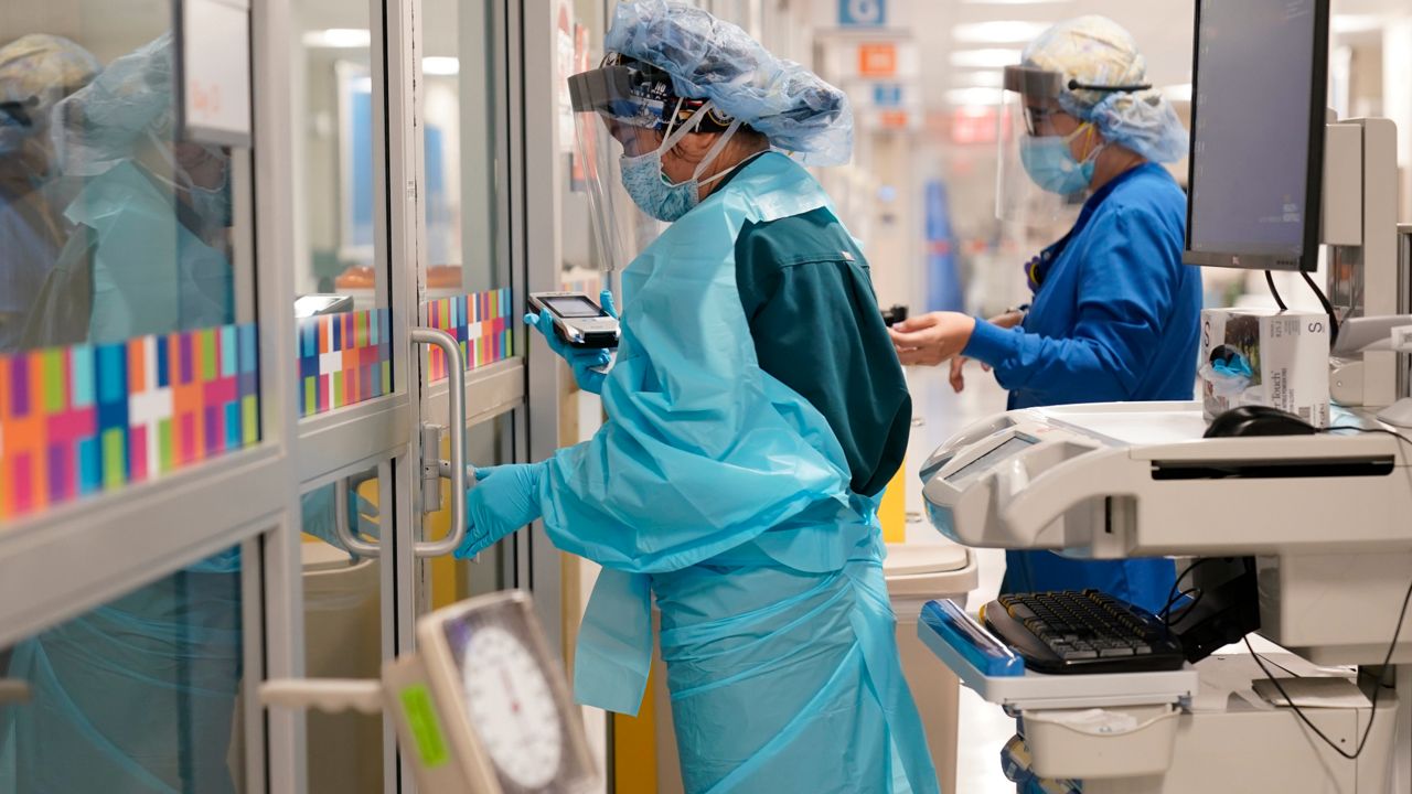 Hospital workers dress in PPE while on shift. (Associated Press)