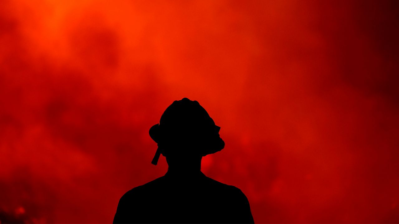 In this Aug. 9, 2018, file photo, a firefighter keeps watch on a wildfire burning in the Cleveland National Forest in Lake Elsinore, Calif. (AP Photo/Ringo H.W. Chiu)