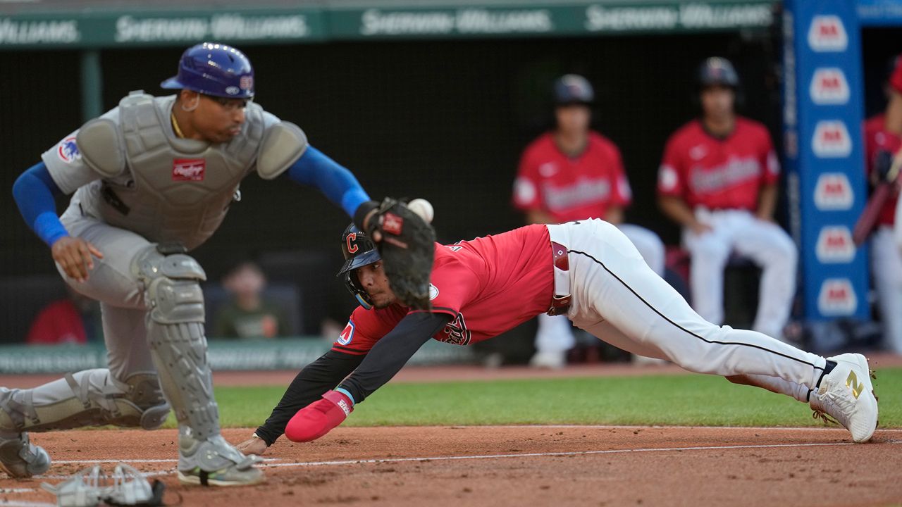 Cleveland Guardians' Andres Gimenez, rear, scores behind Chicago Cubs catcher Christian Bethancourt, front, in the second inning of a baseball game, Tuesday, Aug. 13, 2024, in Cleveland. (AP Photo/Sue Ogrocki)