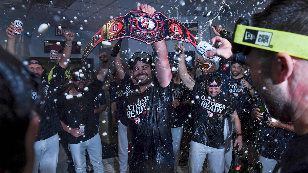 The Cleveland Guardians celebrate in the clubhouse after they defeated the Minnesota Twins to clinch a baseball playoff berth, Thursday, Sept. 19, 2024, in Cleveland. (AP Photo/Nick Cammett)