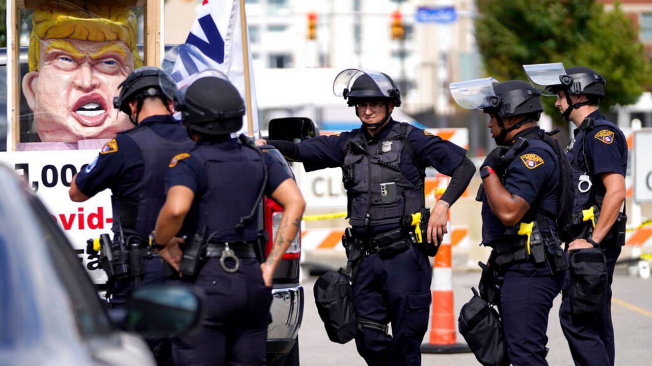 Cleveland Police officers surround a vehicle that approached the perimeter outside the Health Education Campus of Case Western Reserve University, where Republican candidate President Donald Trump and Democratic candidate former Vice President Joe Biden are set to have their first debate, Monday, Sept. 28, 2020, in Cleveland. (AP Photo/Julio Cortez)