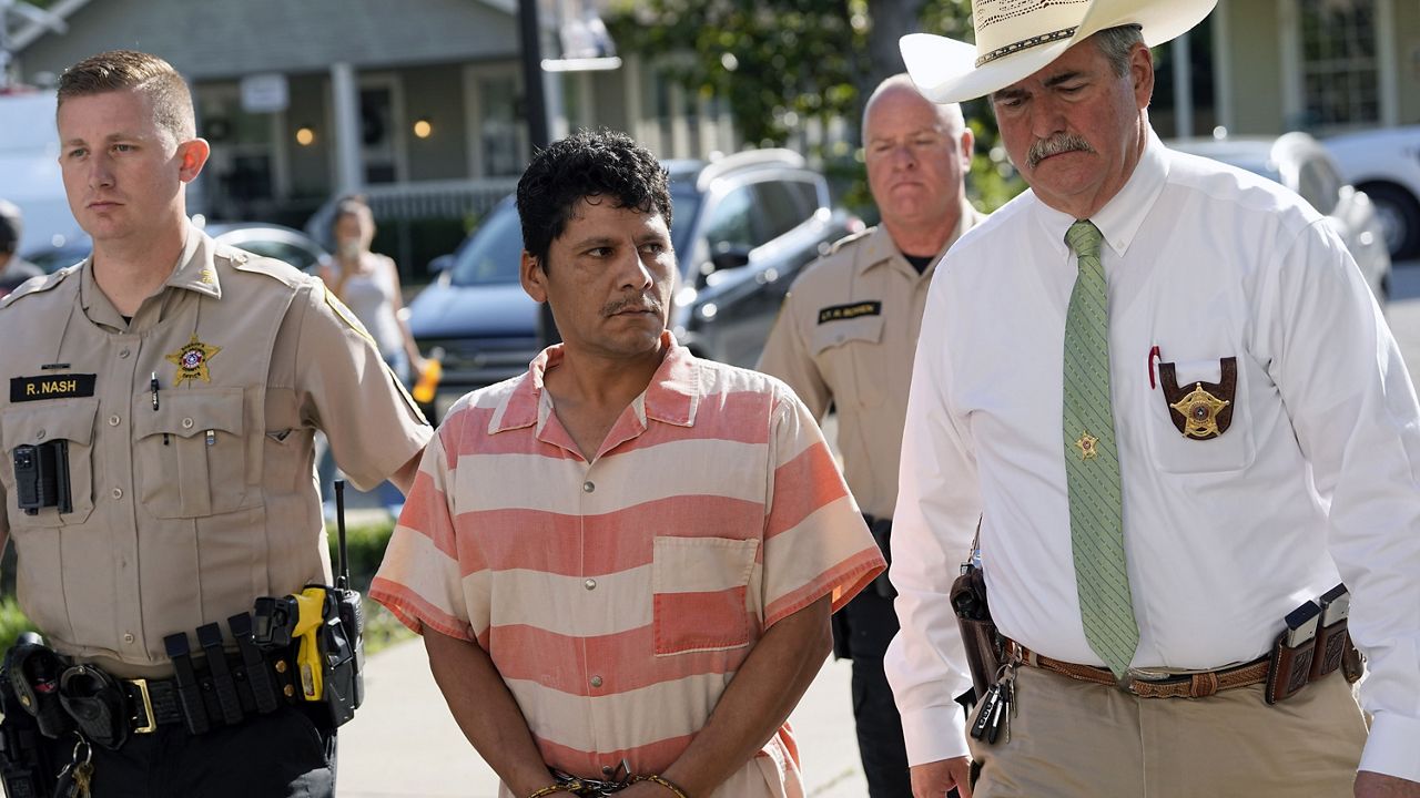 Francisco Oropeza, center, is escorted to the San Jacinto County courthouse by San Jacinto County Sheriff Greg Capers, right, for a hearing Thursday, May 18, 2023, in Coldspring, Texas. Oropeza is suspected of killing five people, including a 9-year-old boy, after neighbors asked him to stop firing off rounds in his yard. (AP Photo/David J. Phillip)