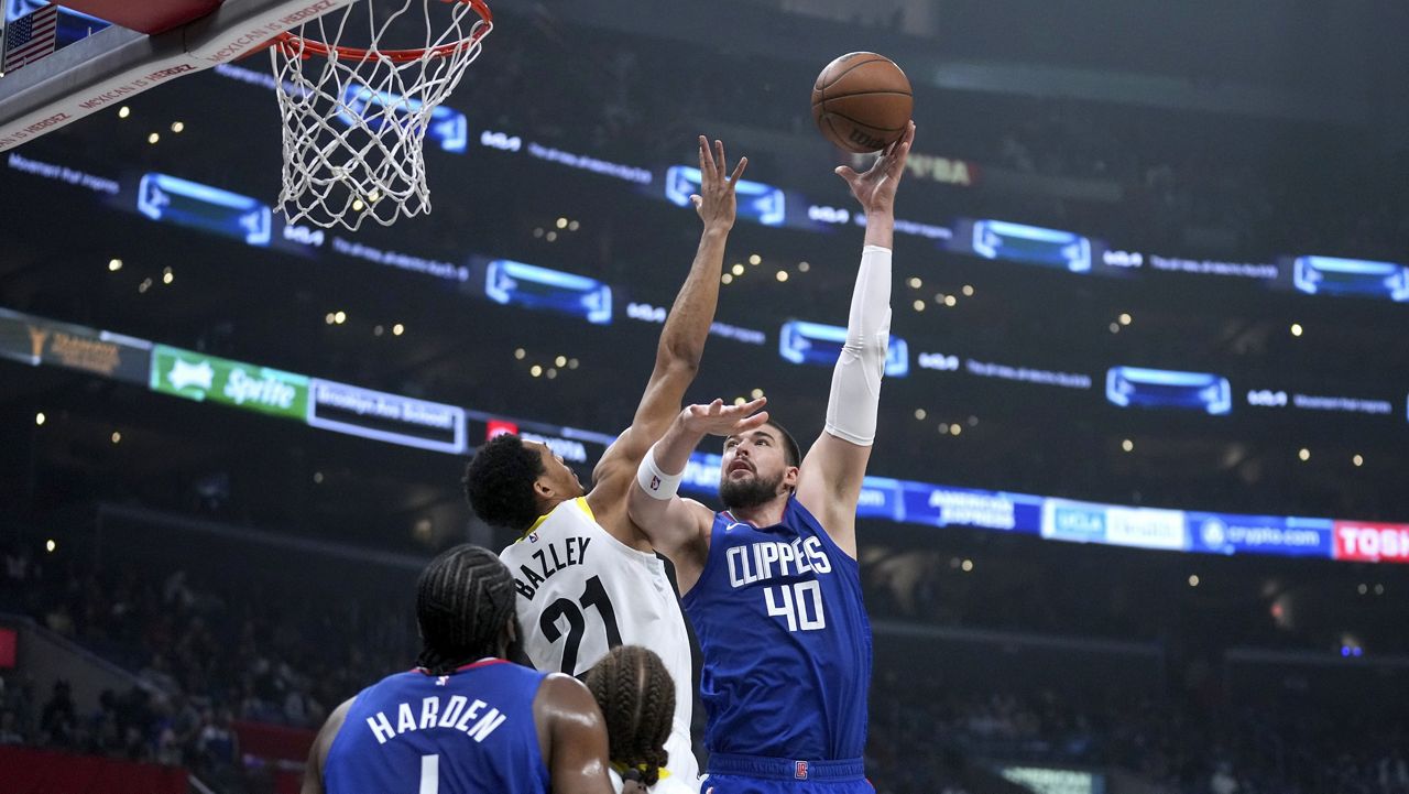 Los Angeles Clippers center Ivica Zubac (40) scores over Utah Jazz forward Darius Bazley (21) as Clippers guard James Harden (1) and Jazz guard Jason Preston watch during the first half of an NBA basketball game in Los Angeles, Friday, April 12, 2024. (AP Photo/Eric Thayer)