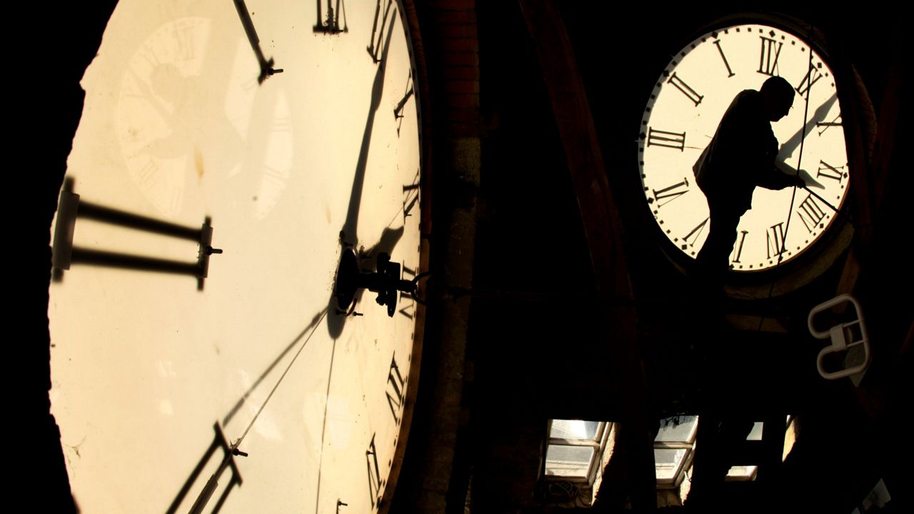 Custodian Ray Keen checks the time on a clock face after changing the time on the clock atop the Clay County Courthouse in Clay Center, Kan., on Nov. 6, 2010. (AP Photo/Charlie Riedel, File)