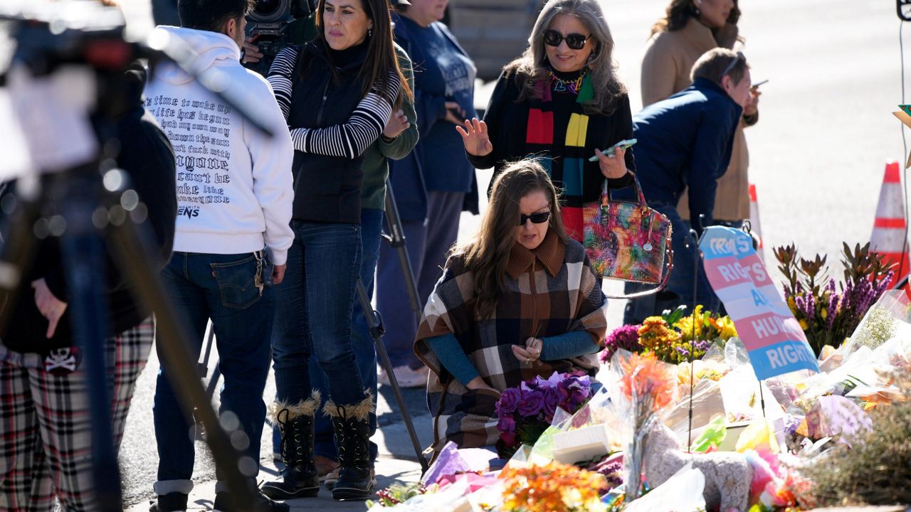 Bouquets of flowers sit on a corner near the site of a mass shooting at a gay bar Monday, Nov. 21, 2022, in Colorado Springs, Colo. (AP Photo/David Zalubowski)