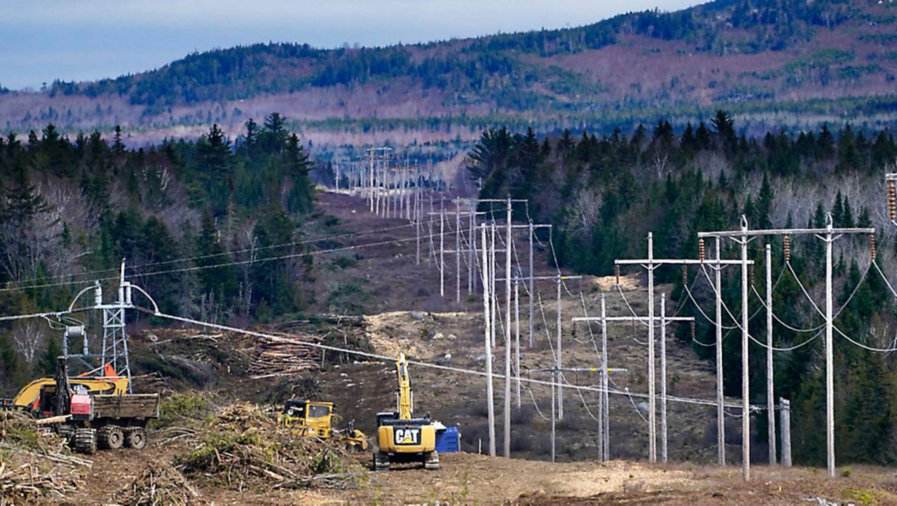 FILE - Heavy machinery is used to cut trees to widen an existing Central Maine Power power line corridor to make way for new utility poles, April 26, 2021, near Bingham, Maine.  A Maine jury concluded on Thursday that developers have a constitutional right to proceed with a $1 billion transmission project, despite being rebuked by state voters in a referendum.(AP Photo/Robert F. Bukaty, File)