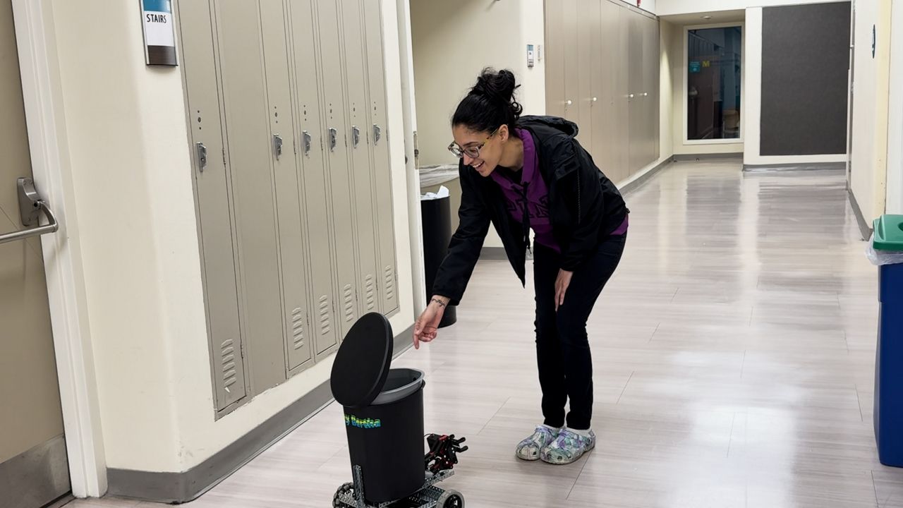 Person using the robot trash can that the group of CMSD students built (Katie Priefer)