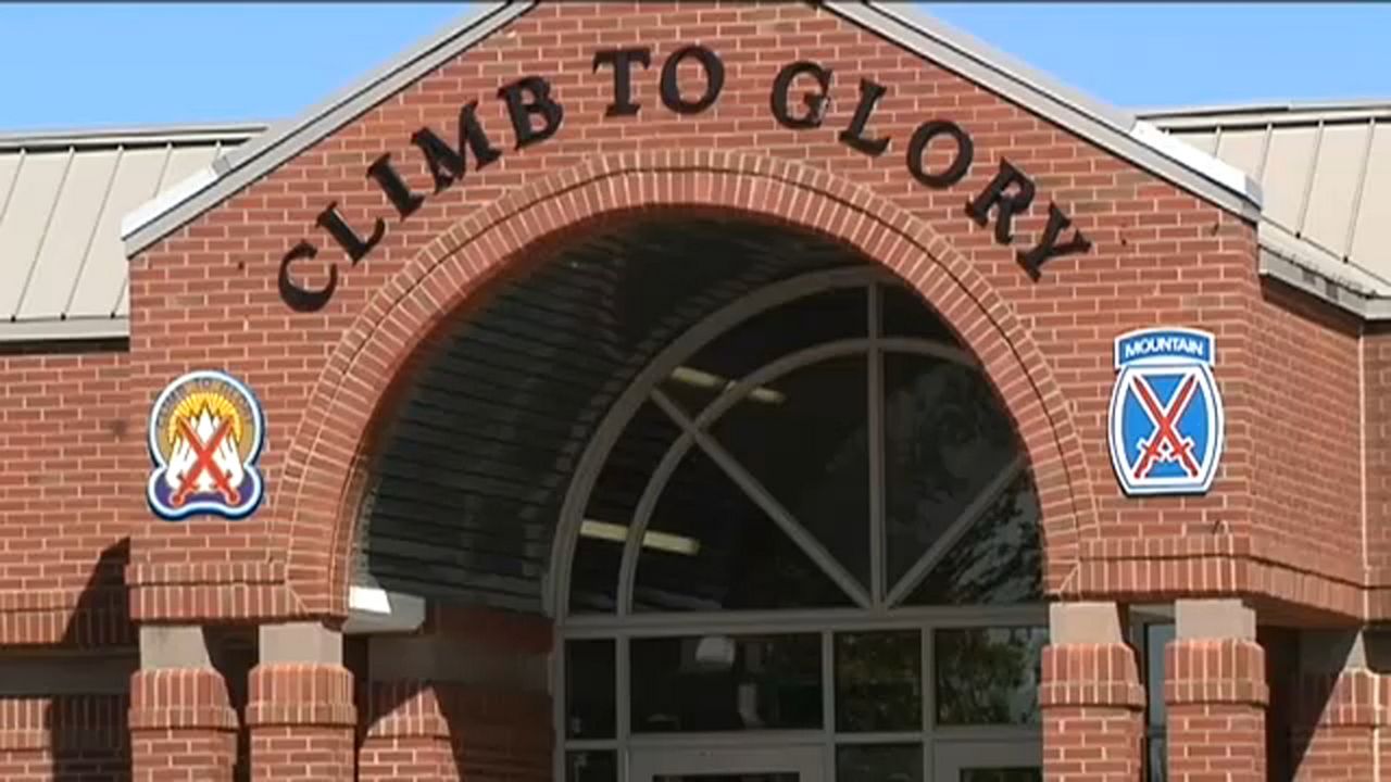 fort drum building exterior, with a brick archway facade that reads 'climb to glory' in black lettering