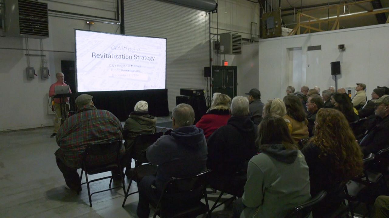 people sitting in regional market warehouse as presenter goes over new plans in powerpoint presentation on a projector