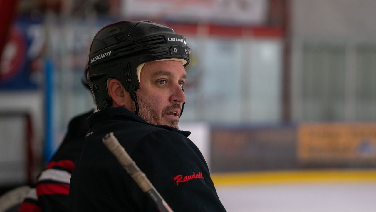 Coach Niel Randall watches as his Louisville Ice Cardinals practice on the ice (Spectrum News 1/Mason Brighton)