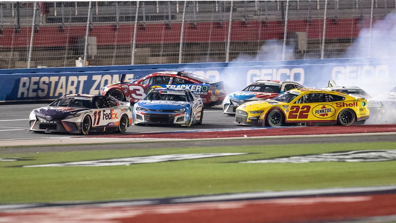 Joey Logano (22), Kyle Larson (5) and Austin Dillon (3) wreck behind Denny Hamlin (11) during a NASCAR Cup Series auto race at Charlotte Motor Speedway, Sunday, May 29, 2022, in Concord, N.C. (AP Photo/Matt Kelley)