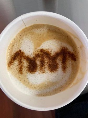 A coffee beverage decorated with the Ken Anderson Alliance logo.