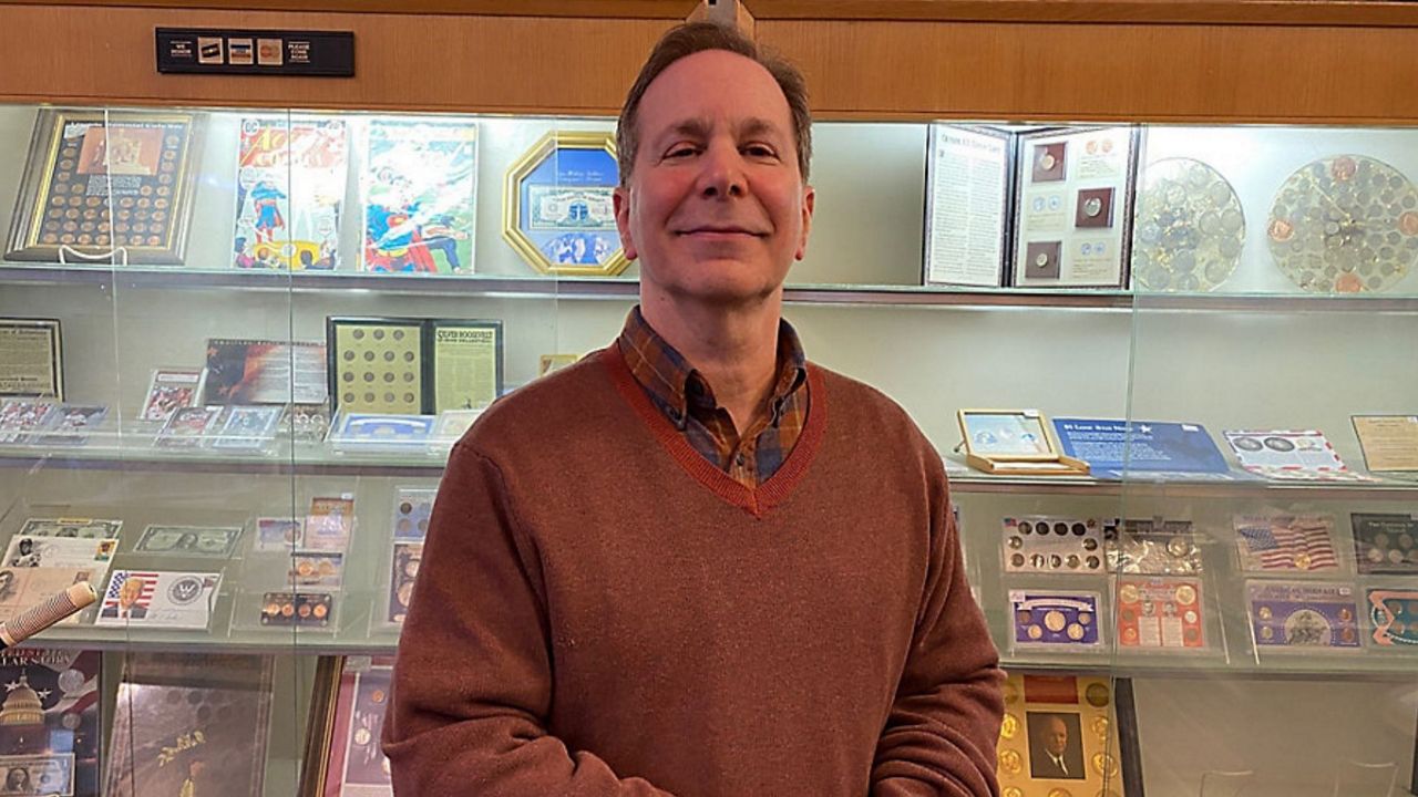 Gary Cohen stands in front of a shelf of coins in Cleveland, OH on Wednesday, Jan. 12th, 2022. (Spectrum News 1/Jade Nash)