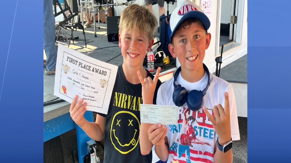Cole Perkins (left) and Hayes Browder (right) proudly show off their first-place award and prize check after winning Granville’s Got Talent with their classic rock performance. (Courtesy of James Browder)