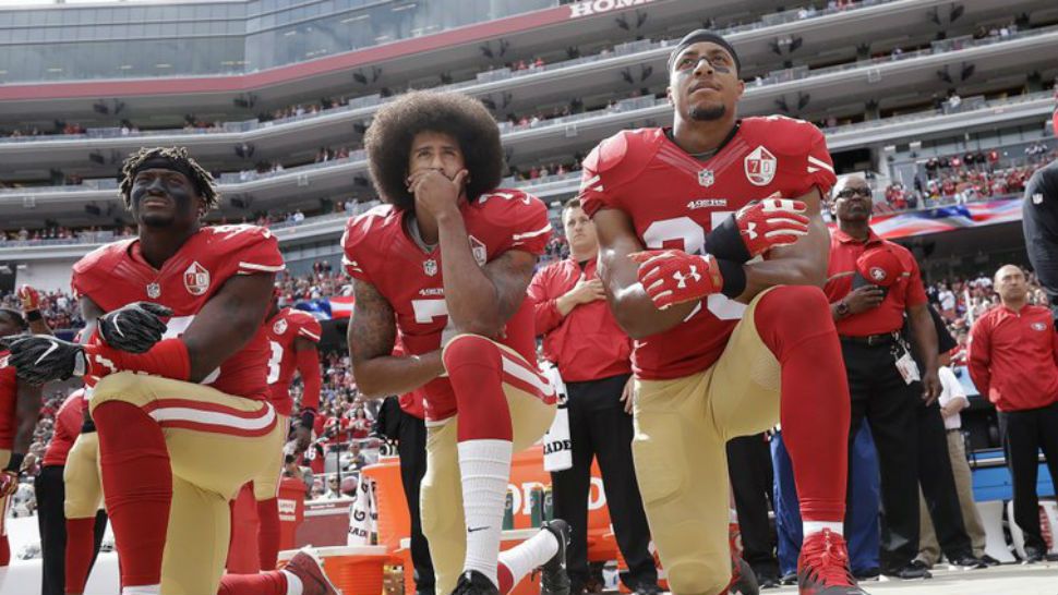 FILE - In this Oct. 2, 2016 file photo, from left, San Francisco 49ers outside linebacker Eli Harold, quarterback Colin Kaepernick and safety Eric Reid kneel during the national anthem before an NFL football game against the Dallas Cowboys in Santa Clara, Calif. An arbitrator is sending Kaepernick’s grievance with the NFL to trial, denying the league’s request to throw out the quarterback’s claims that owners conspired to keep him out of the league because of his protests of social injustice. (AP Photo/Marcio Jose Sanchez, File)