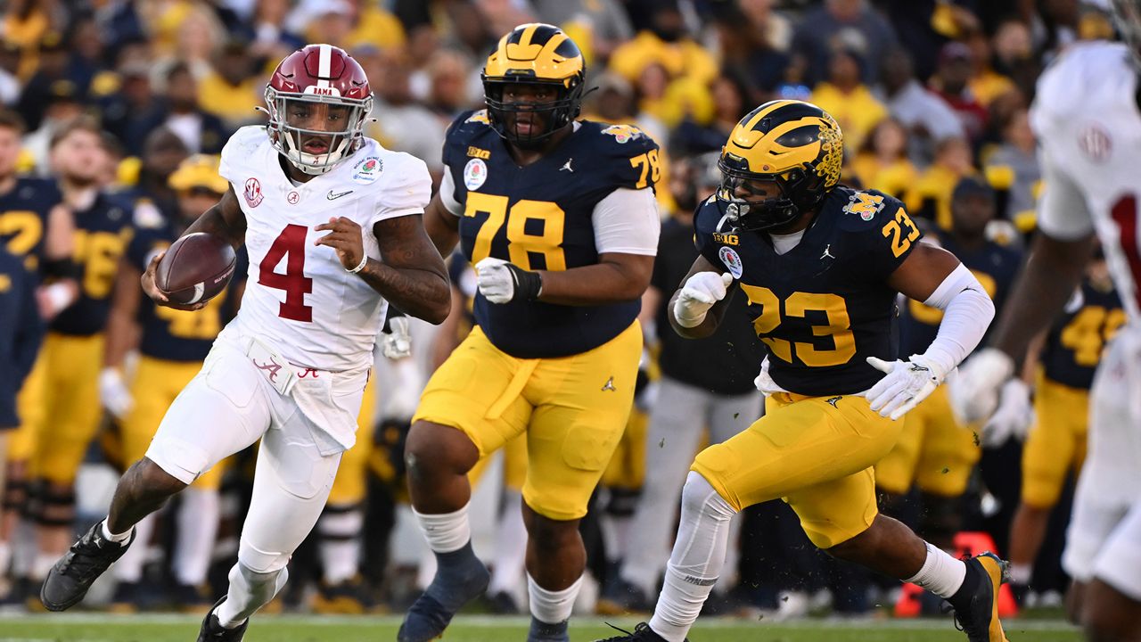 Alabama quarterback Jalen Milroe (4) runs past Michigan defensive lineman Kenneth Grant (78) and linebacker Michael Barrett (23) during the first half of the Rose Bowl CFP NCAA semifinal college football game Monday, Jan. 1, 2024, in Pasadena, Calif. (AP Photo/Kyusung Gong)