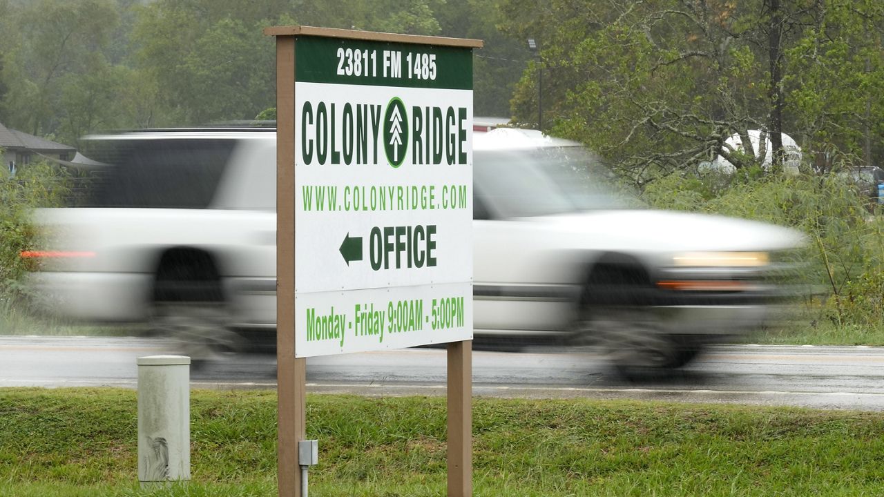 A vehicle passes the Colony Ridge office sign Tuesday, Oct. 3, 2023, in Cleveland, Texas. The booming Texas neighborhood is fighting back after Republican leaders took up unsubstantiated claims that it has become a magnet for immigrants living in the U.S. illegally and that cartels control pockets of the neighborhood. (AP Photo/David J. Phillip)