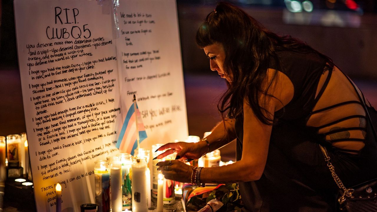 People light up candles at a makeshift memorial for the victims of Saturday's fatal shooting at Club Q in Colorado Springs, Colo., outside Rocco's WeHo in West Hollywood, Calif., Sunday, Nov. 20, 2022. (AP Photo/Damian Dovarganes)