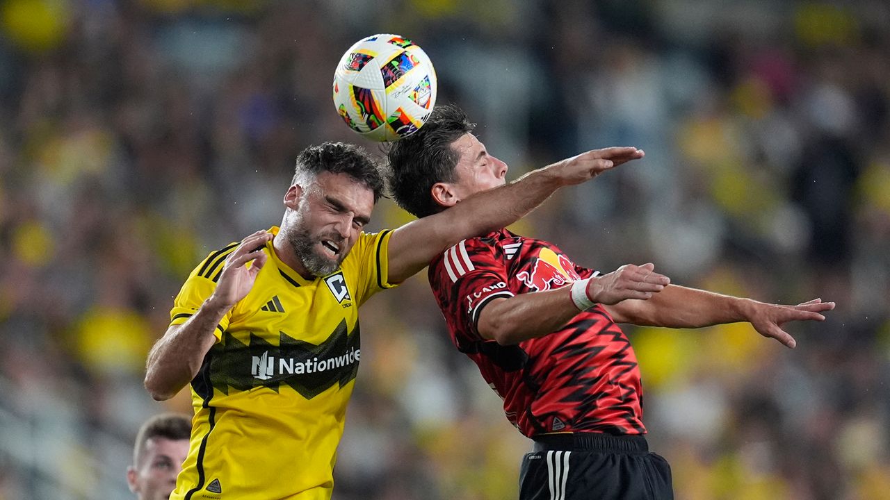 Columbus Crew defender Rudy Camacho, left, and New York Red Bulls forward Dante Vanzeir, right, head the ball in the first half of a first-round soccer match of the MLS Cup playoffs, Tuesday, Oct. 29, 2024, in Columbus, Ohio. (AP Photo/Sue Ogrocki)