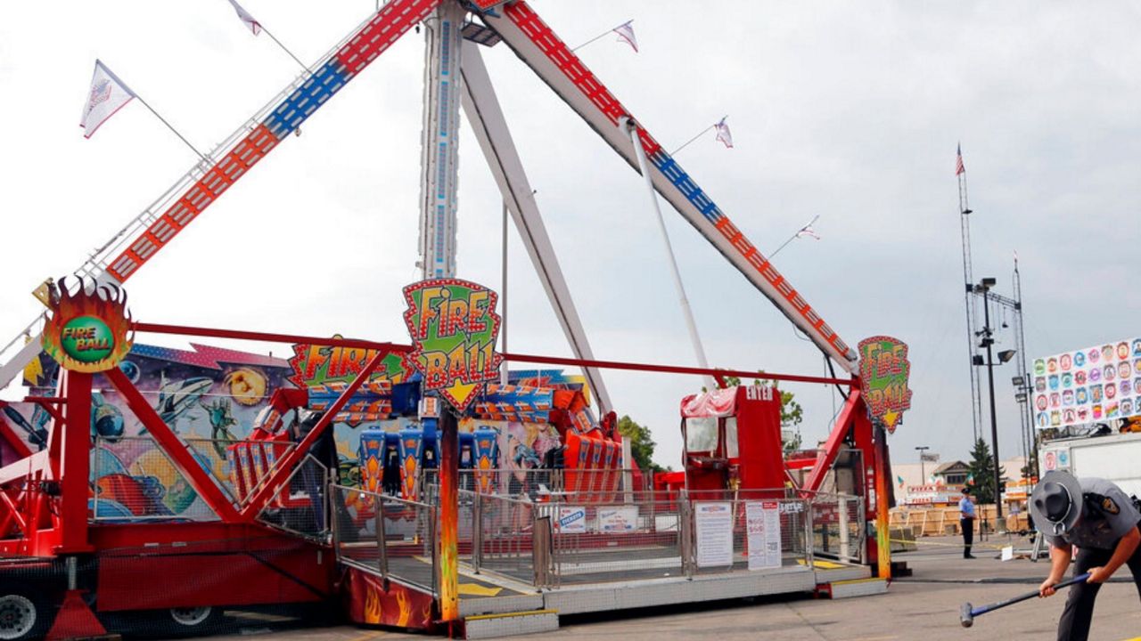 FILE- In this July 27, 2017 file photo, an Ohio State Highway Patrol trooper removes a ground spike in front of the Fire Ball ride at the Ohio State Fair, in Columbus, Ohio. Ohio has beefed up its amusement ride inspections four years after the ride broke apart at the 2017 Ohio State Fair and killed a high school student and injured several others. But some ride operators and festival organizers say the state's inspectors are overreaching and shutting down rides over issues that aren't safety-related. (AP Photo/Jay LaPrete, File)