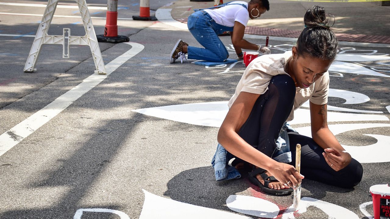 Artist Jessica McAlpin paints a crosswalk paints a crosswalk in downtown Louisville at 4th and Jefferson St. (Charles Wilkerson)