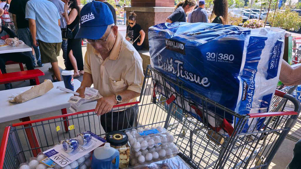 Un cliente revisa sus recibos de compra mientras espera en la fila del patio de comidas de la tienda Costco Wholesale en Glendale, California. 