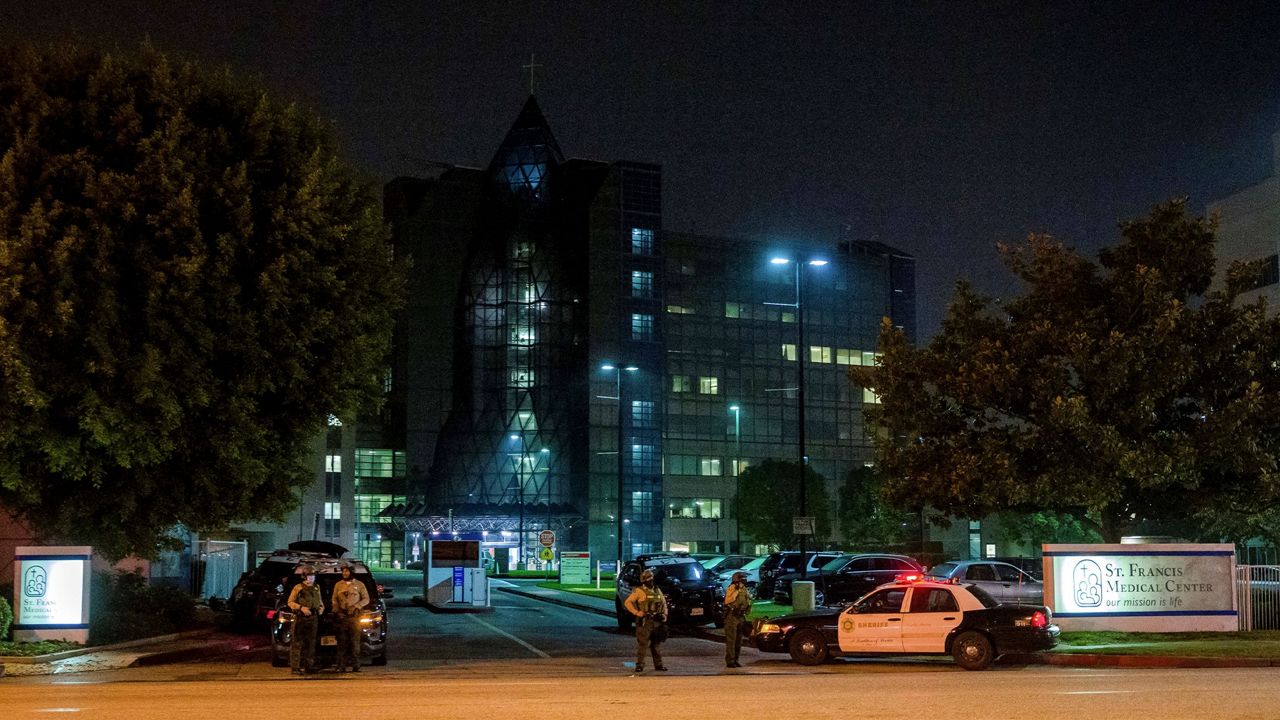 In this Sept. 13, 2020, file photo, LA County Sheriff's deputies guard the entrance to St. Francis Medical Center after two deputies were shot late Saturday, Sept. 12, while sitting inside their patrol vehicle guarding a Metro station in Compton, Calif. (AP Photo/Jintak Han)