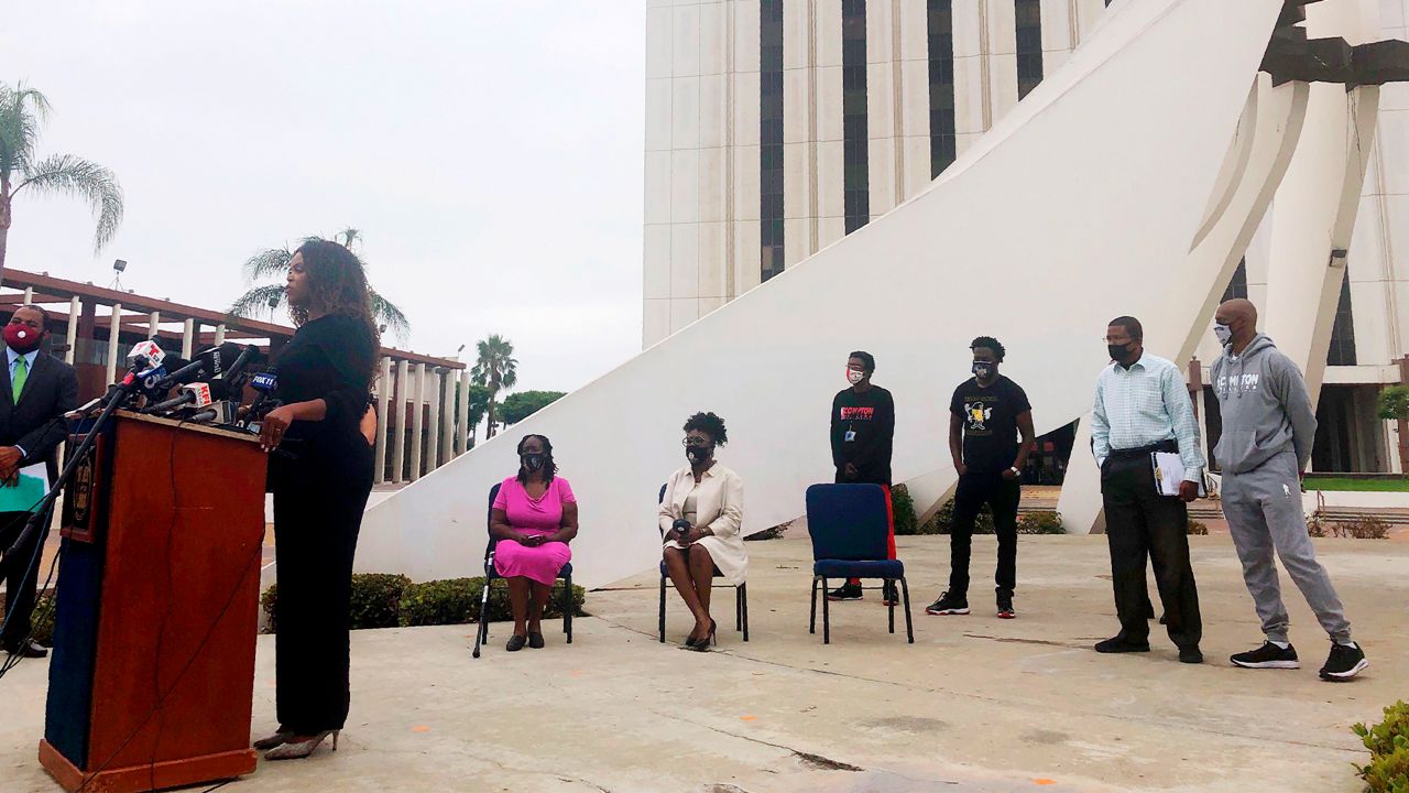 Compton, Calif., Mayor Aja Brown, left, calls on the state attorney general's office and the U.S. Department of Justice to investigate the Los Angeles County Sheriff's station at a news conference in Compton Tuesday, Aug. 4, 2020. A violent gang of sheriff's deputies who call themselves "The Executioners" control a patrol station in Compton through force, threats, work slowdowns and acts of revenge against those who speak out, a deputy alleged in a legal claim. (AP Photo/Stefanie Dazio)