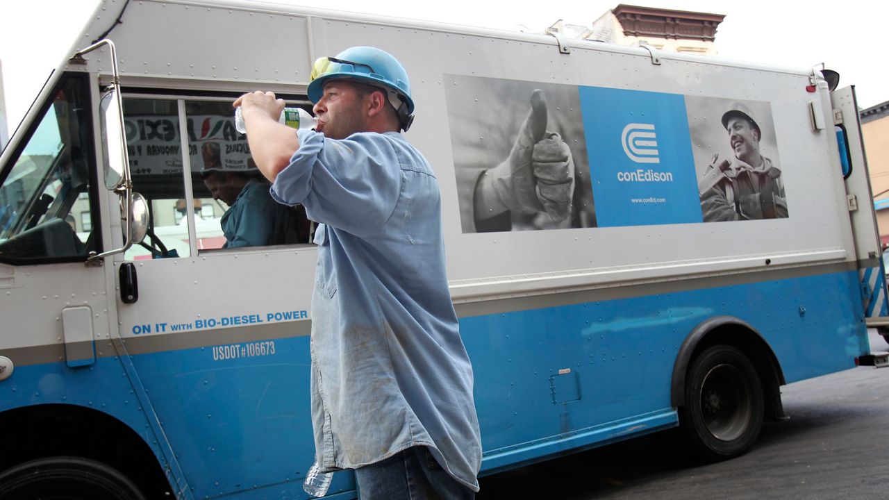 A Con Edison worker drinks from a water bottle amid extreme heat in New York City.  (AP Photo/Seth Wenig)