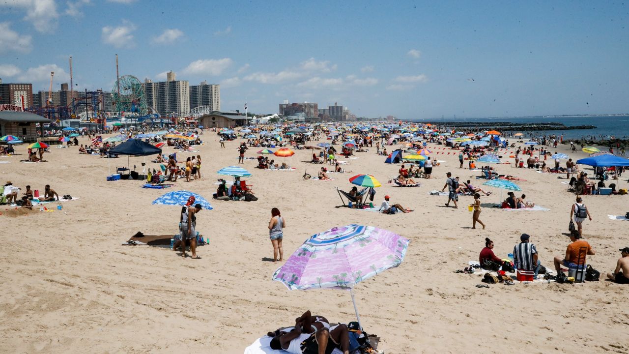 Revelers enjoy the beach at Coney Island, Saturday, July 4, 2020, in the Brooklyn borough of New York. (AP Photo/John Minchillo)