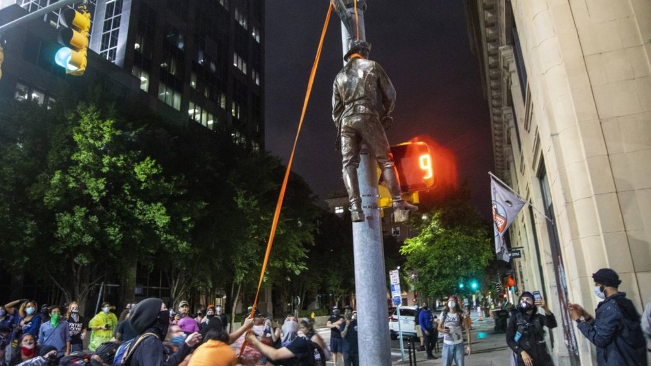 confederate statue hangs from street light
