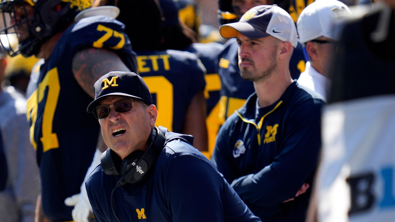 Michigan head coach Jim Harbaugh, front left, watches against Rutgers as analytics assistant Connor Stalions, right, looks on during an NCAA college football game in Ann Arbor, Mich., Sept. 23, 2023. Stalions was suspended by the university on Oct. 20 and is at the center of a sign-stealing scheme that is being investigated by the NCAA. (AP Photo/Paul Sancya)